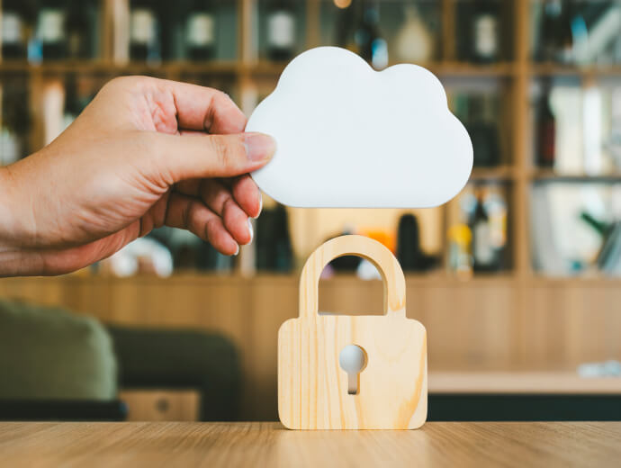 A hand holding a toy cloud over a toy padlock
