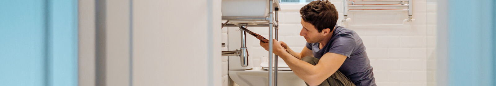 young man fixing a bathroom sink